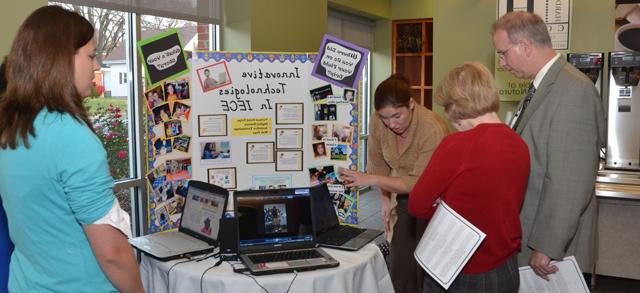 Dr. Michael V. Carter and his wife, Debbie, from left, talk with Sara Parker and Danielle Lanham about interdisciplinary early childhood education. (Campbellsville University Photo by Joan C.  McKinney)