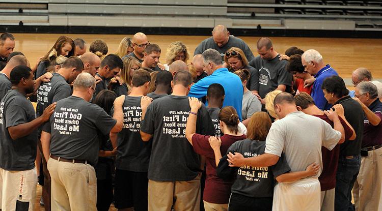  Ed Pavy, Campbellsville University's campus minister, in blue shirt, leads the commissioning prayer during a send off at CU's Powell Athletic Center for the seven-day Costa Rica mission trip. (Campbellsville University Photo by Richard RoBards)