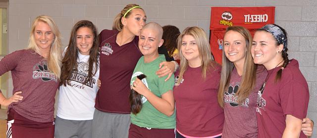 Haley Dallas, fourth from left, receives a kiss on her newly shaved head from her fellow Lady  Tiger Tennis Team member Megan Charity after Haley shaved her head at St. Baldrick's. Other tennis team members congratulating her were from left: Meg Brown, Jenna Sallee, Jade  Letheby, Anna Tumanyan and Lindy Charity. (Campbellsville University Photo by Mikayla  Smith)