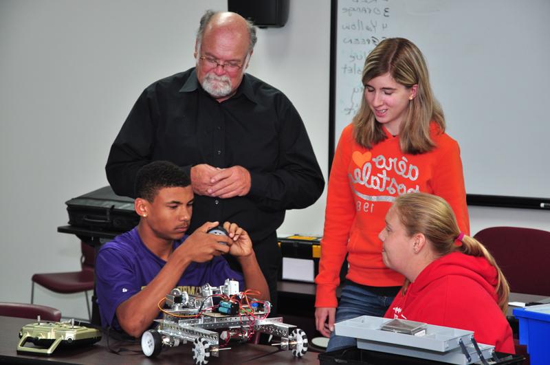 Dave Rauch, instructor, looks over work being done at the robotics class by from left: Fayth Wise of Taylor County Schools, top; Brookylan Cox of Taylor County Schools and Austyn Thornton of Campbellsville. (Campbellsville University Photo by Austin Yates)